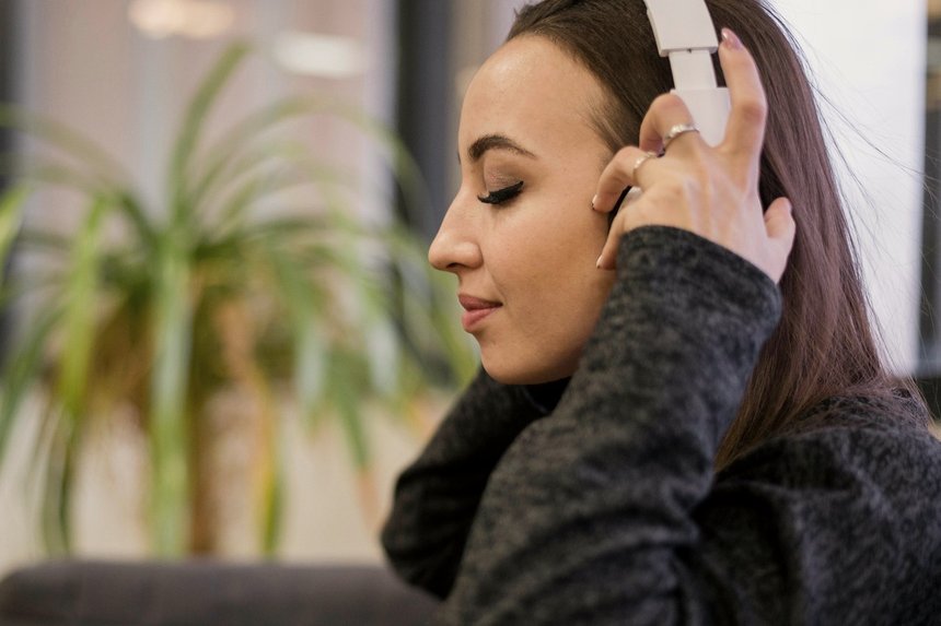 Frau mit Kopfhörern in entspanntem Zustand – Selbsthypnose als Audio